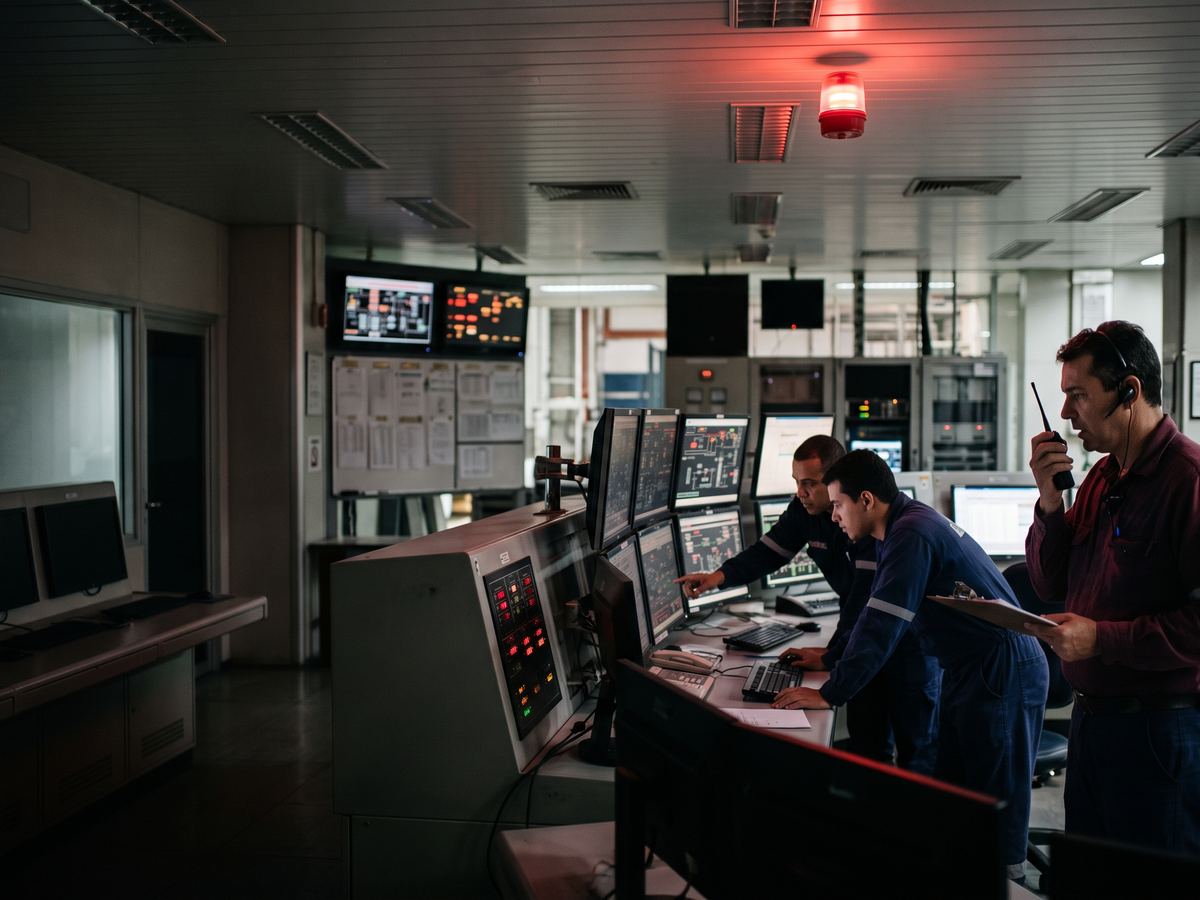 Operadores de sala de controle respondem a um alarme de processo